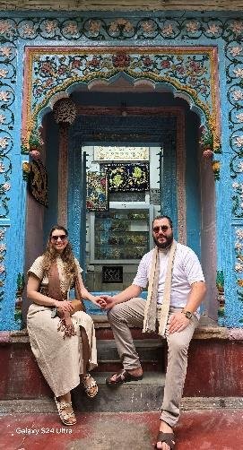 Visitors seated at a colorful historic haveli doorway in Nau Ghara, Old Delhi