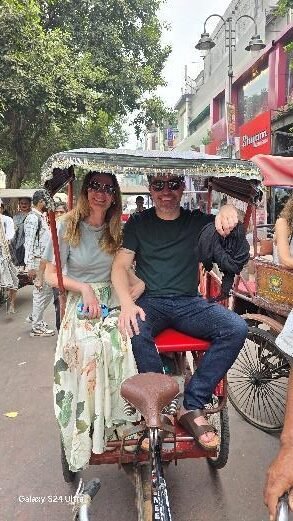 Travelers riding a cycle rickshaw in Old Delhi